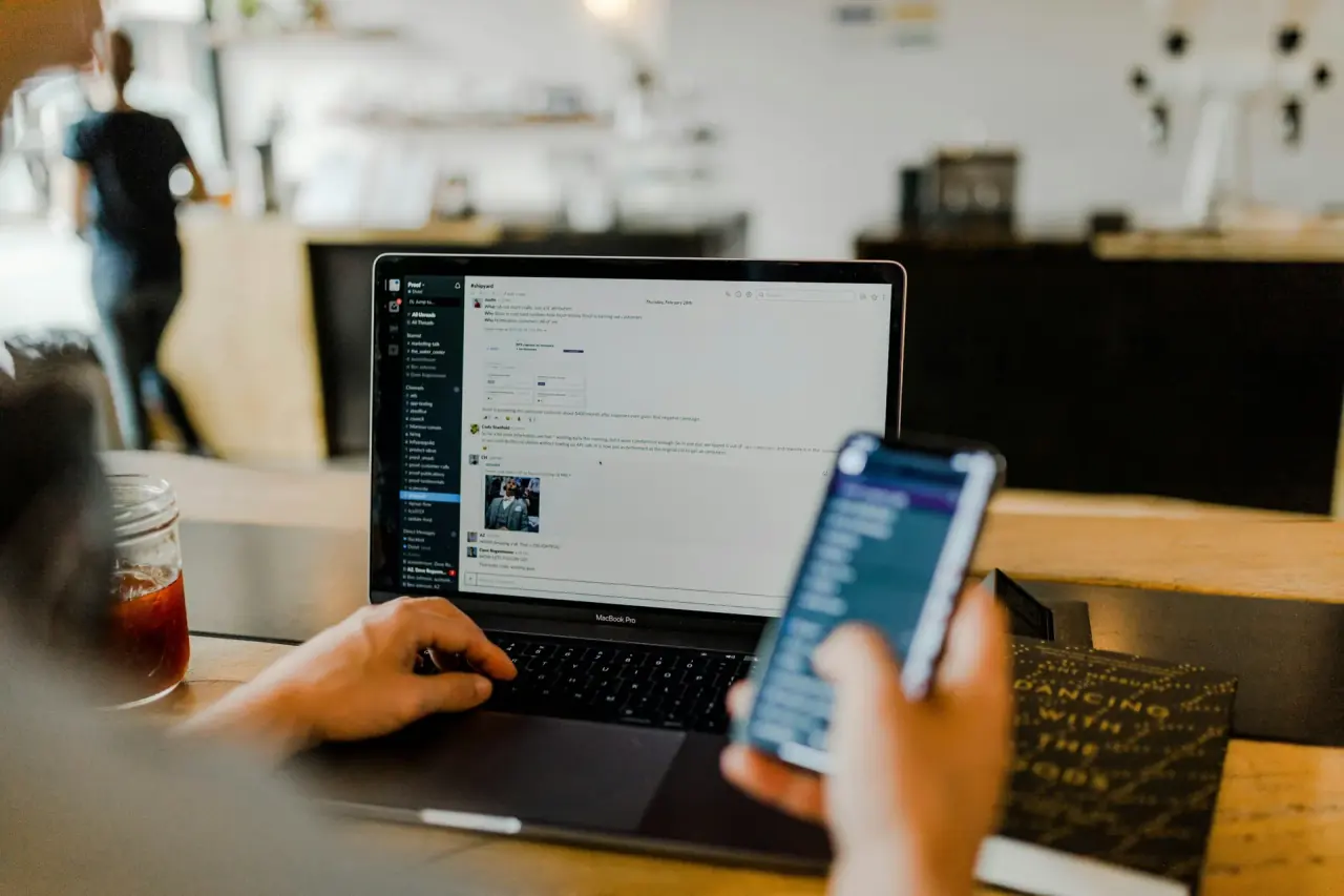 Persona trabajando con una computadora portátil en una mesa de reuniones